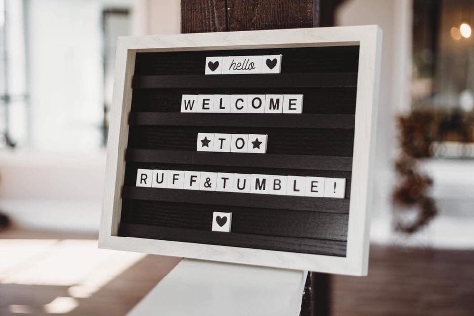 Letter board sign reading “hello, welcome to Ruff & Tumble!” inside the salon